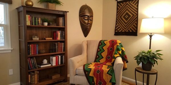 Black History Month decor: Cozy reading nook with African mask and patterned throw.