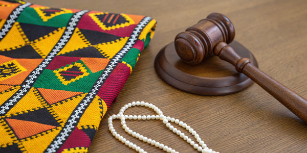 Kente cloth, a gavel, and pearls arranged as D9 sorority and fraternity gifts.