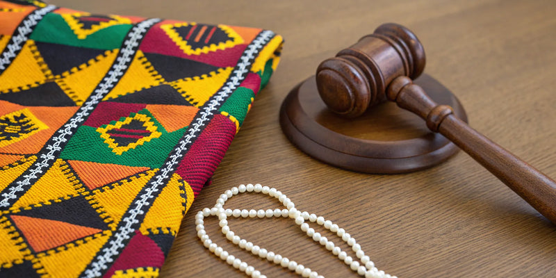 Kente cloth, a gavel, and pearls arranged as D9 sorority and fraternity gifts.