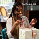 Woman opening a gift with red ribbon in a blurred indoor setting
